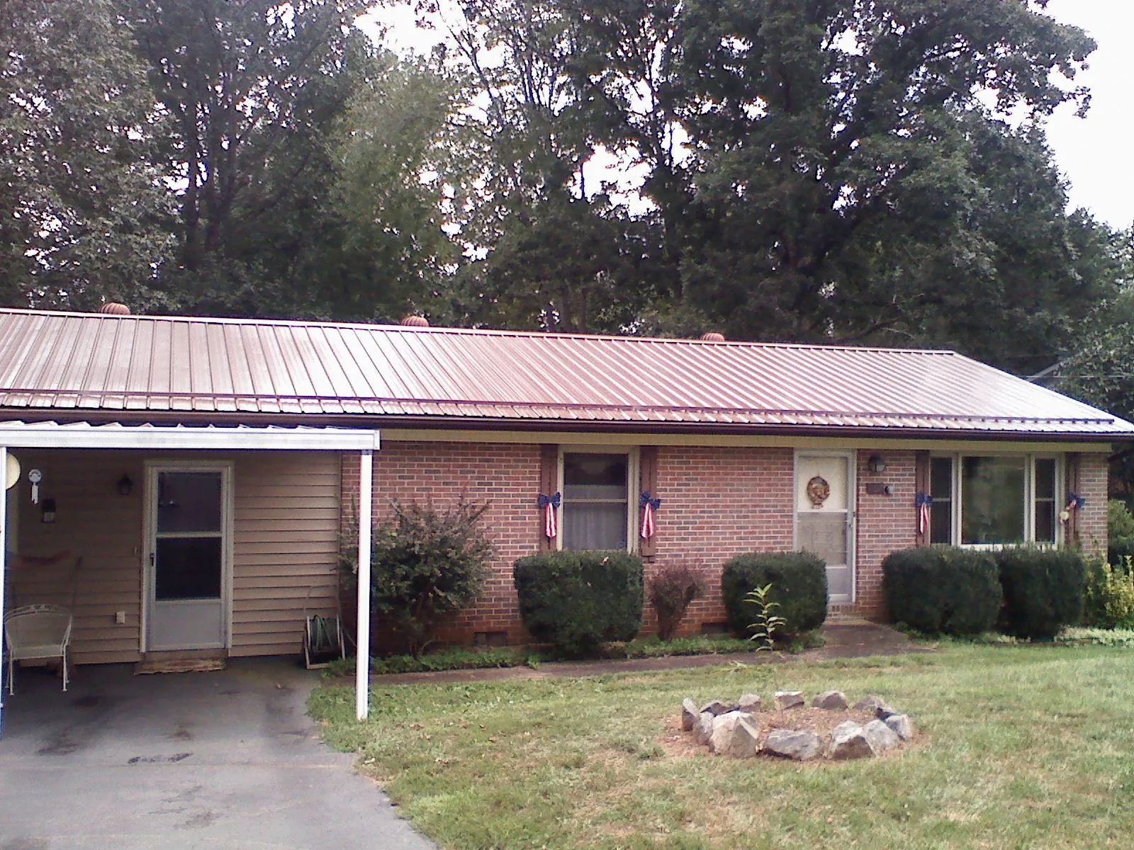 Bronze metal roof and carport on a brick ranch home — Roof Repair work by our crew in Glenns Ferry